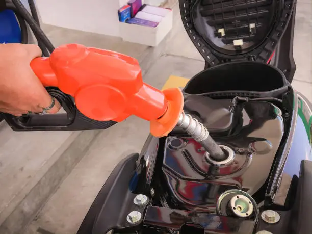 Photo of Filling gasoline into the motorcycle's fuel tank.