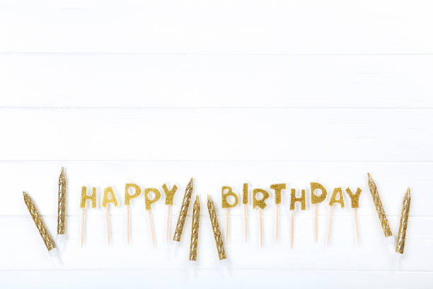 Happy Birthday candles on white wooden table