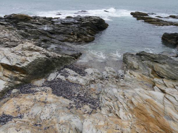istock Water flows into a small cove formed by rocks 1189889348
