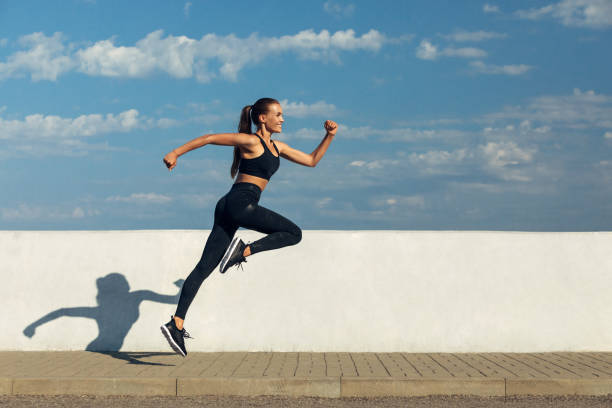 トレーニングが楽しい時 - healthy lifestyle women jumping happiness ストックフォトと画像