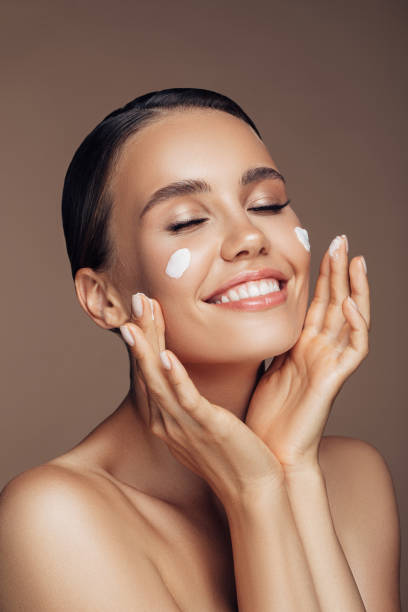 istock Beautiful woman applying cream on her face 1189890809