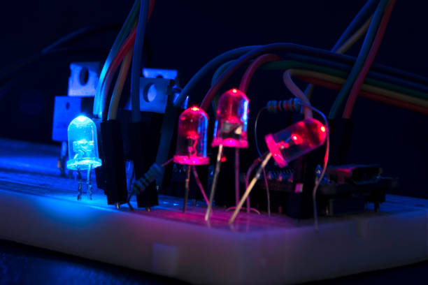 доска arduino нано прототипы борту транзисторы резисторы светодиоды красный и синий в свечение в темноте на черной коже - breadboard стоковые �фото и изображения