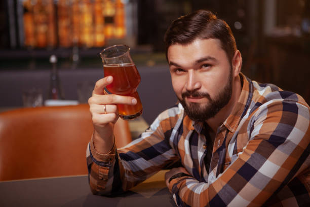 istock Handsome bearded man drinking beer at the pub 1189892427