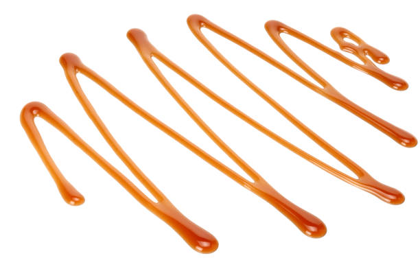 An assorted straight and curved lines and spots of sweet apricot jam on white table