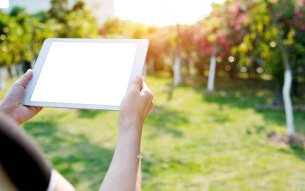 istock Woman hand using a digital tablet outdoors 1189897336