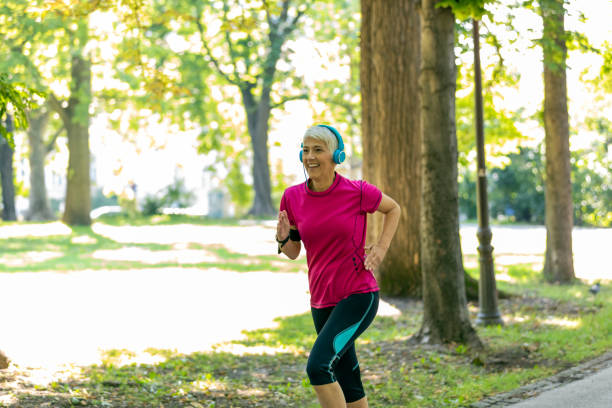 istock Mature Woman is Jogging Outdoors in Nature 1189897667