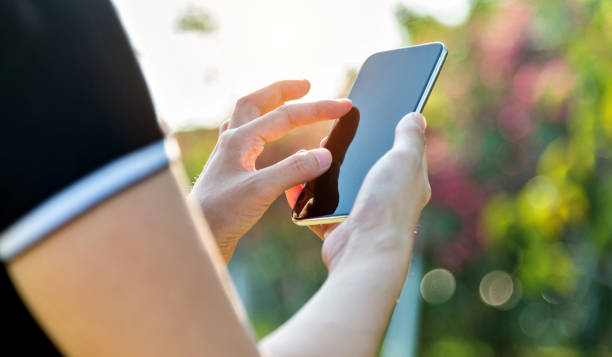 istock Woman hand using a smart phone outdoors 1189898198