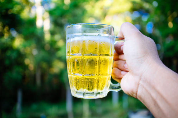 southeast asian man happily drinking beer