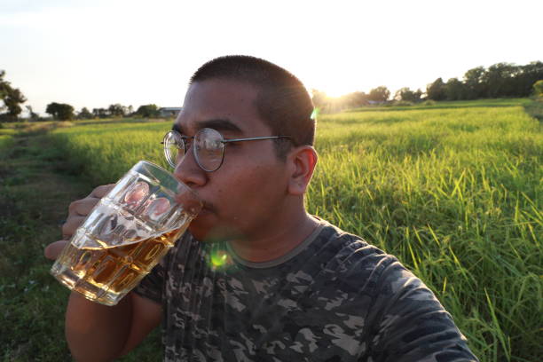 istock southeast asian man happily drinking beer 1189898572