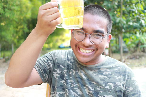 istock southeast asian man happily drinking beer 1189898592