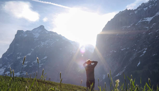 istock Mature man walks through alpine field at sunrise 1189900990
