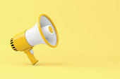 Single yellow and white electric megaphone with a handle stands on a yellow background