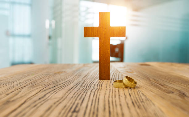 istock Wedding rings and cross on table 1189904009