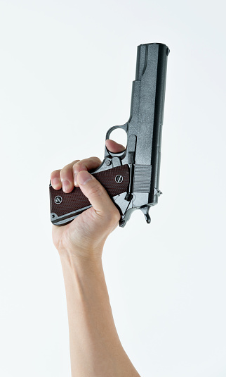 Woman hand holding a gun on white background.