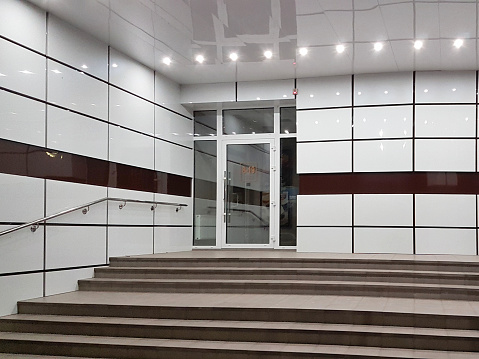 Kremenchuk, Ukraine - 9 9 2019: Design of the entrance to the building of the commercial premises. The combination of doors and staircases with handrails and tiled decoration of the facade.