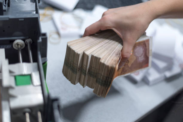 istock Bank employees sorting and counting money inside bank vault. 1189907337