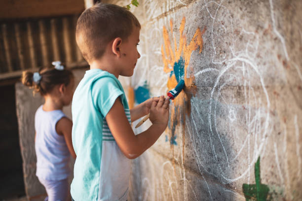istock Cheerful little children having fun painting wall 1189907366