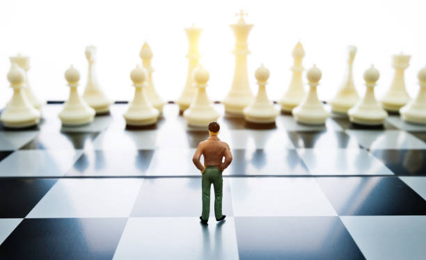 istock Man figurine standing on a chessboard 1189907531