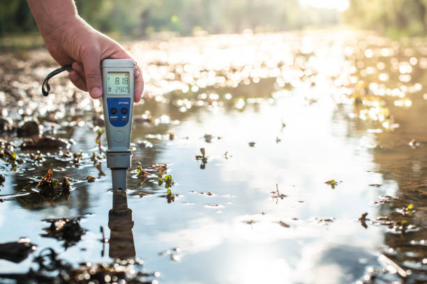 Measure water content with digital device.  PH meter. Measure water content with digital device. Sunrise over the water. PH meter. soil sample stock pictures, royalty-free photos & images