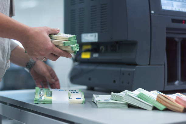 istock Bank employees sorting and counting money inside bank vault. 1189907680