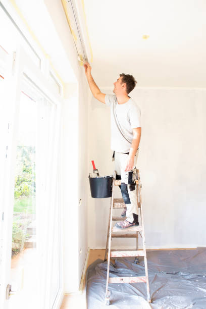 tiré du jeune homme peignant le mur de l'aparmtent - painting house house painter repairing photos et images de collection