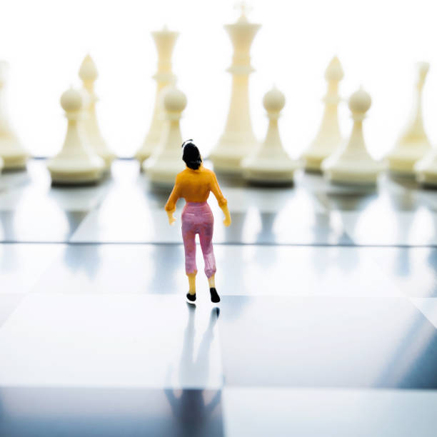 Woman figurine standing on a chessboard