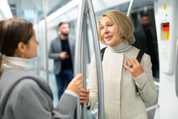 istock Two women passengers talking in subway car on way to work 1189910560