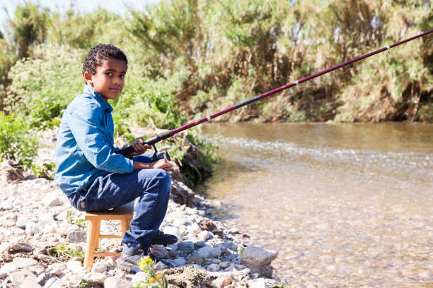 istock Boy fishing on river 1189913064