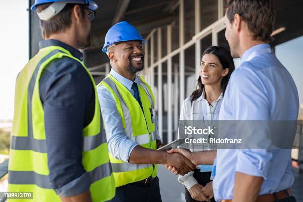 Ingenieur Und Geschäftsmann Handshake Auf Der Baustelle Stockfoto und mehr Bilder von Baugewerbe