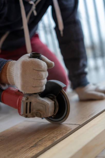 istock repair and decoration. a man cuts ceramic tiles with a grinder. 1189914416