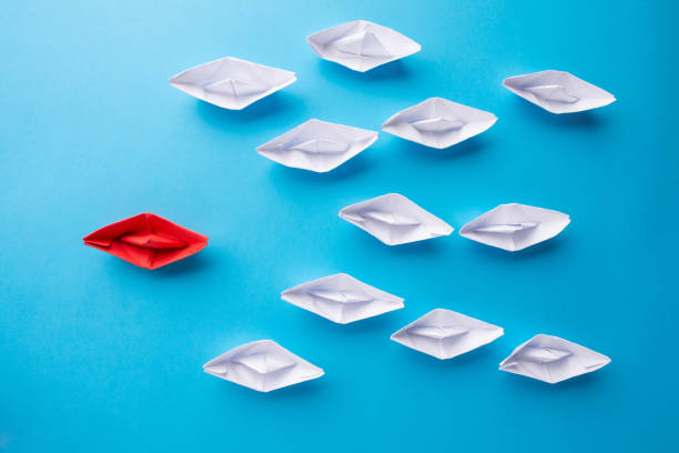 istock A red ship as a leader. White following it. Blue background. Picture from above 1189914736