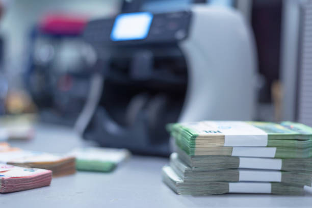 istock Bundles of banknotes divided into groups with currency straps placed on the electronic counting machine 1189917141