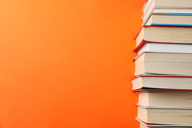 istock Stack of books on orange background, space for text 1189918133