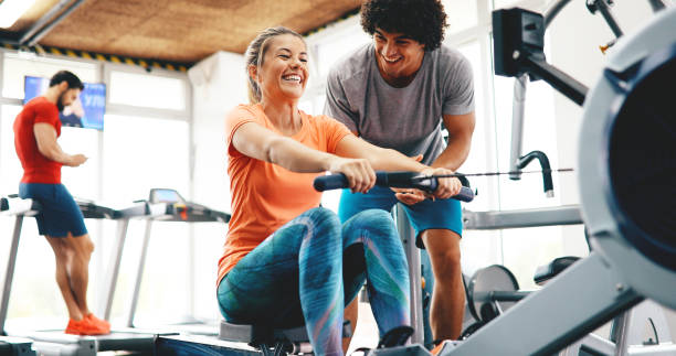 istock Personal trainer helping a young beautiful woman 1189919712