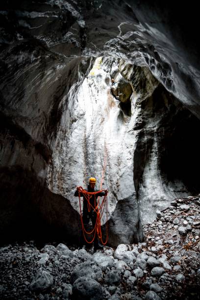 istock An canyoning adventurist reeling a climbing rope in a cave 1189919938