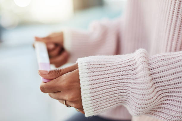 How long do I have to wait? Cropped shot of an unrecognizable woman sitting on her bed alone and waiting for a pregnancy test result at home pregnancy test stock pictures, royalty-free photos & images