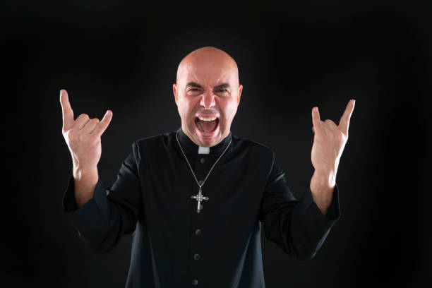 istock Priest bald rock and roll fingers crazy gesture 1189921371