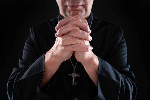 istock Priest pastor praying with hands on black 1189921479