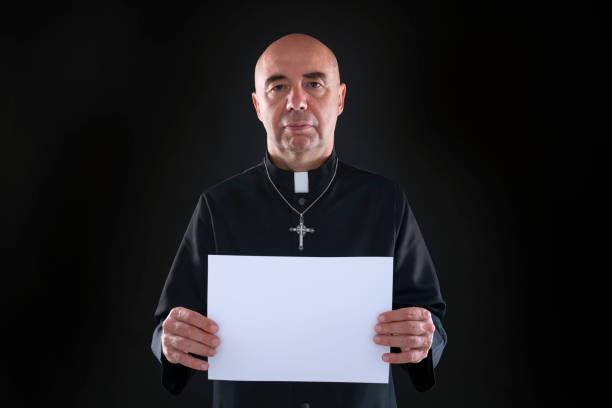 Bald priest holding copy space black paper