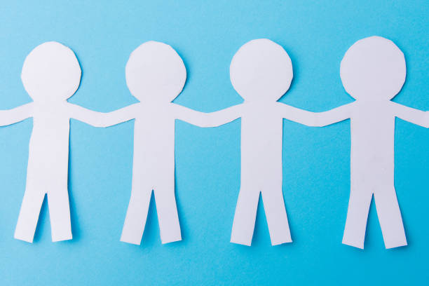 istock White paper people holding hands. Blue background. Place for text 1189921621