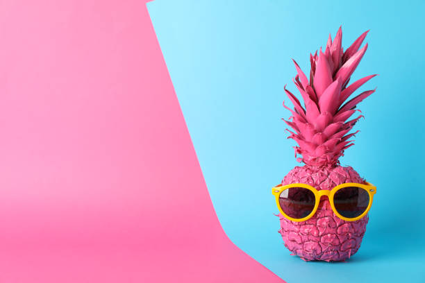 istock Painted pink pineapple with sunglasses on two tone background, space for text 1189922557