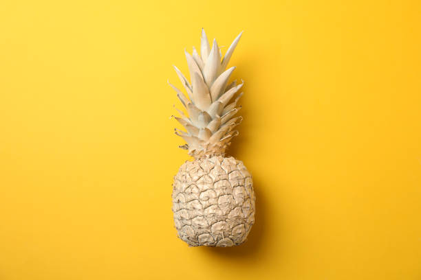 istock Painted gold pineapple on yellow background, space for text 1189922673