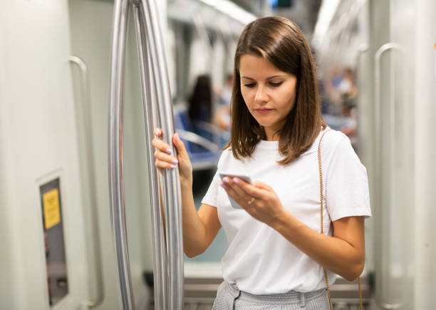 istock Woman using phone in subway car 1189922725