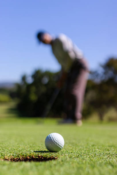 istock Golfer putting golf ball into the hole 1189925556