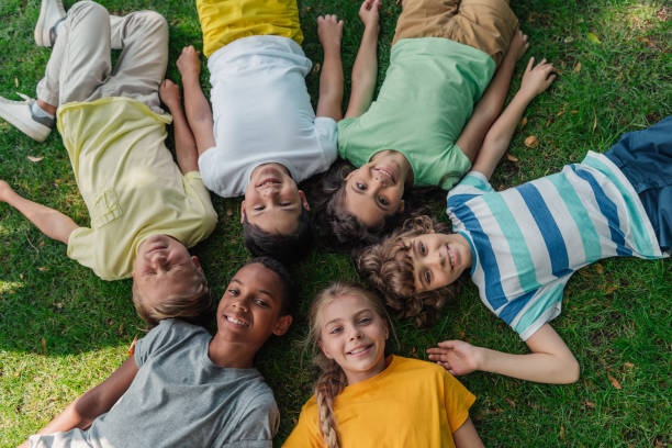 istock top view of happy multicultural kids lying on grass 1189925609