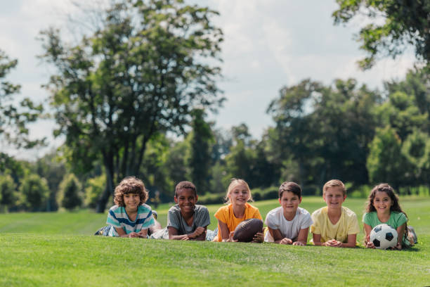 istock happy multicultural kids lying on grass with balls 1189925613