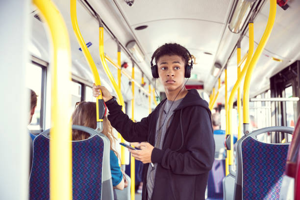 ragazzo con cellulare in viaggio in autobus - transportation bus mode of transport public transportation foto e immagini stock