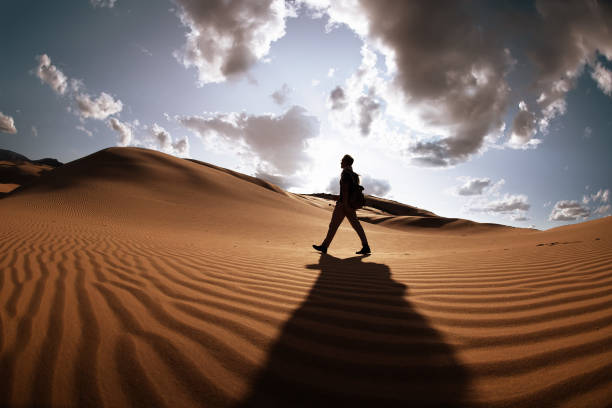 istock Confident man goes in desert at sunset 1189926072