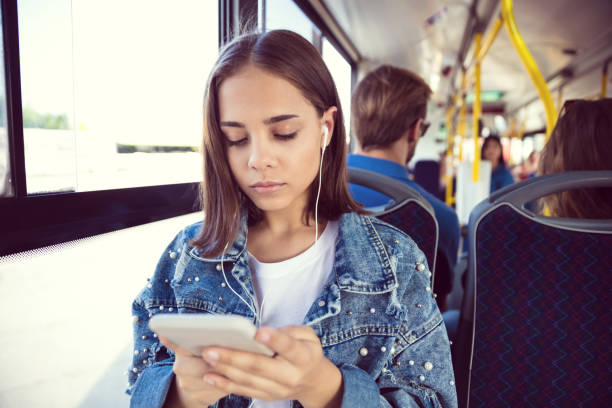 istock Girl using mobile phone in bus 1189926407
