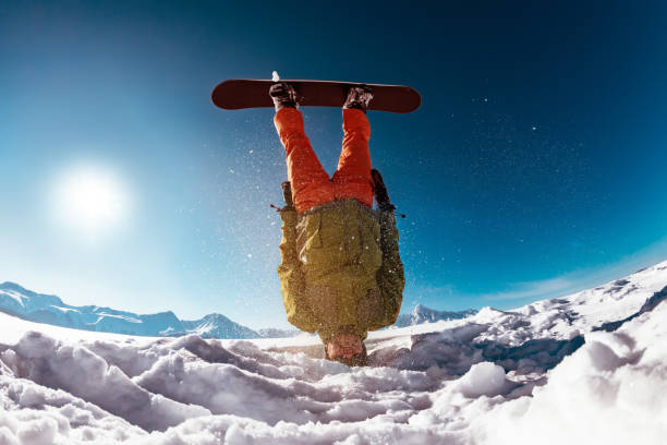 istock Snowboarder stands on head against mountains 1189926433